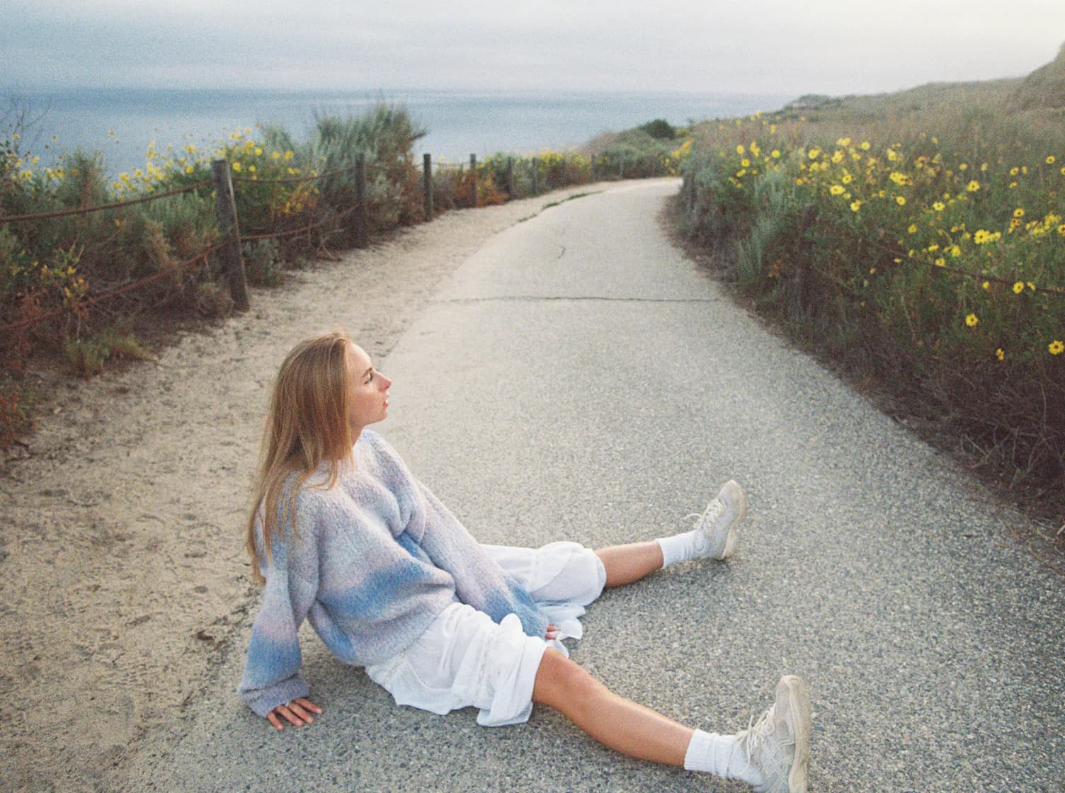 Original photo of a woman sitting on a coastal road